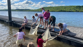 A group of students on a dock using two fish seine nets to catch fish in the Ohio River